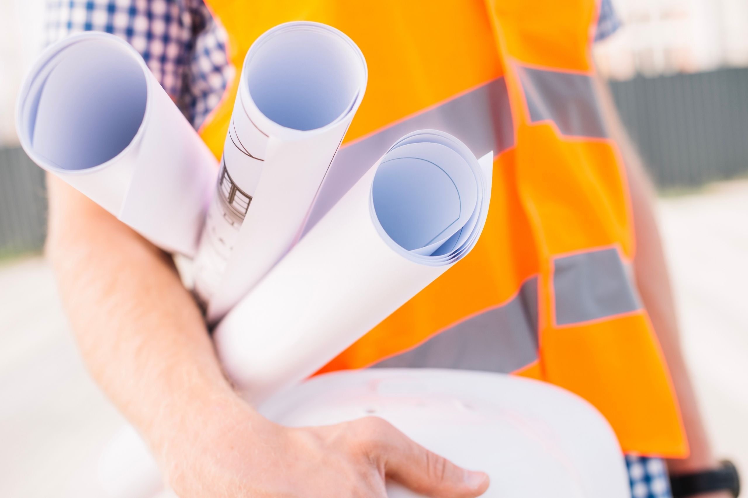 Man met bouwtekening onder zijn arm